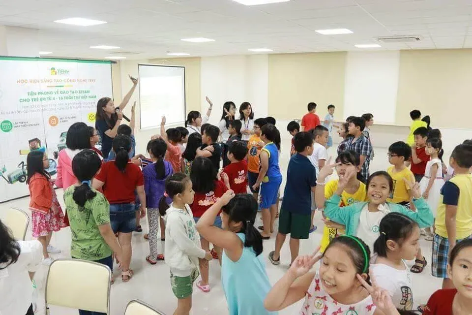 Crowd of children gathered in a room at an event.